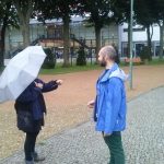 Mensch ohne Schirm spricht mit Mensch mit Schirm über Judo